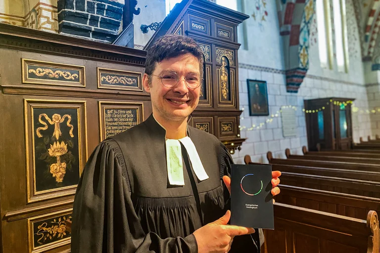 Ein Pastor mit einem Gesangbuch in einer Kirche 